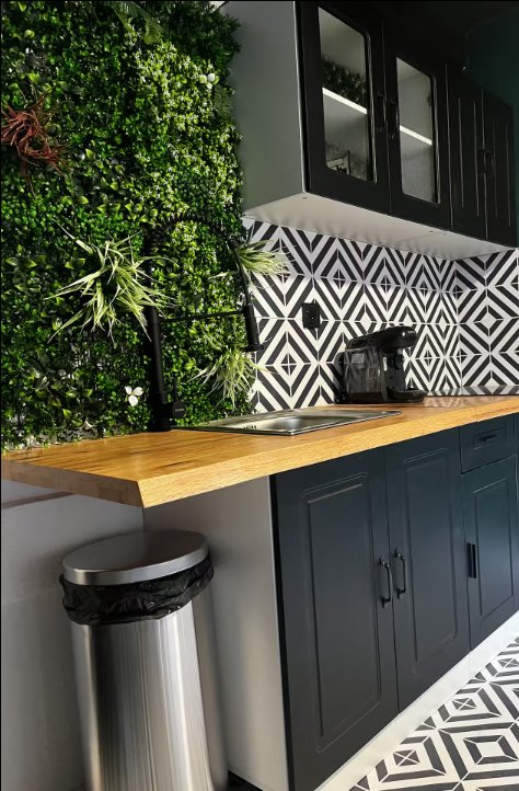 Salon avec TV et fauteuils noirs